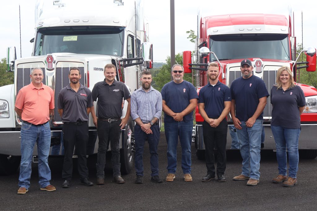 Members of Paccar and Kenworth of Pennsylvania Team in front of a white and red commercial truck